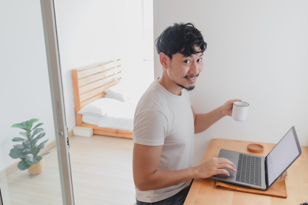 Hombre feliz está trabajando en su concepto de apartamento de trabajo desde casa