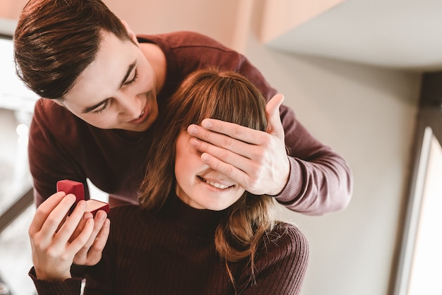 El hombre feliz hace una oferta de matrimonio a su novia.