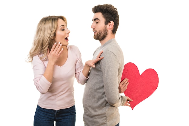 El hombre feliz hace una sorpresa con el símbolo del corazón a una mujer.