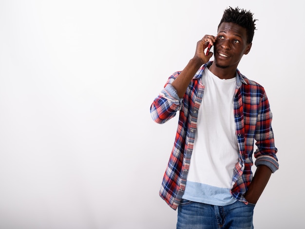 Hombre feliz joven pensativo sonriendo y hablando por teléfono