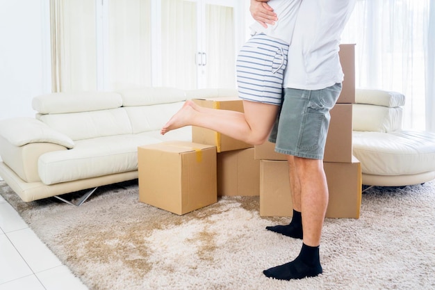 Hombre feliz levantando a su esposa en su nueva casa