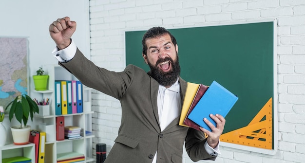 Hombre feliz con libro de trabajo y libros listos para la escuela de lecciones