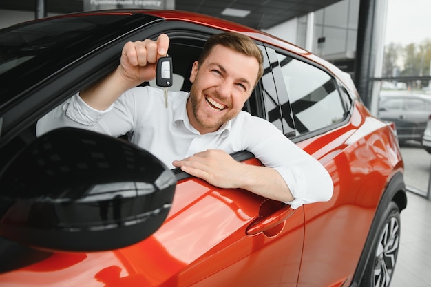 Hombre feliz mostrando la llave de su auto nuevo