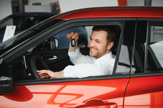 Hombre feliz mostrando la llave de su auto nuevo