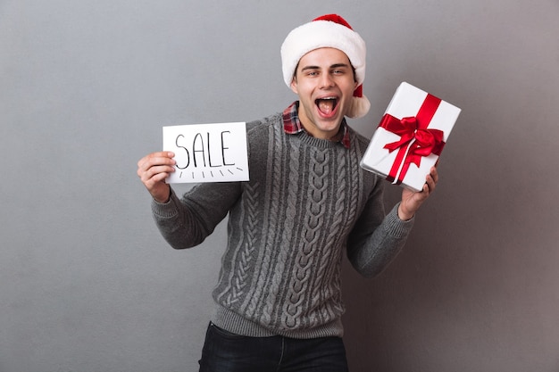 Hombre feliz en navidad santa sombrero con regalo