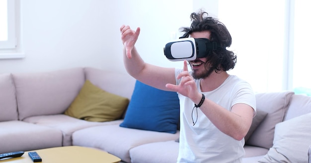 hombre feliz obteniendo experiencia usando gafas VR-headset de realidad virtual en casa