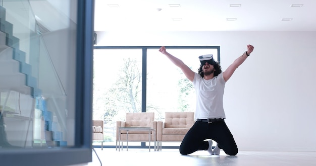 hombre feliz obteniendo experiencia usando gafas VR-headset de realidad virtual en casa