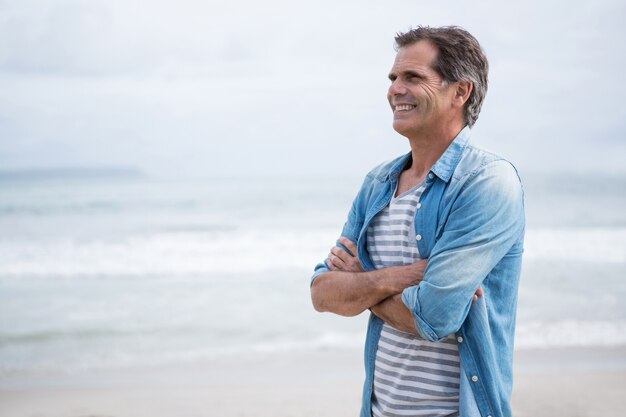 Hombre feliz de pie en la playa