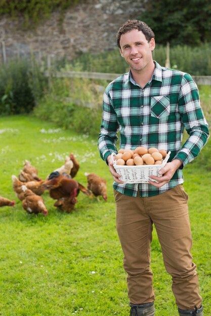 Hombre feliz que muestra una cesta llena de huevos