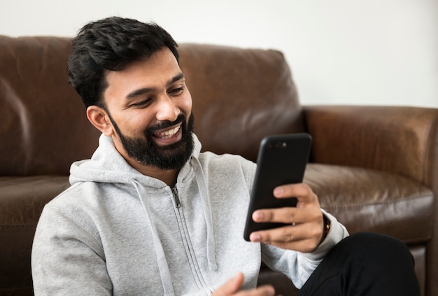 Hombre feliz que usa el teléfono móvil