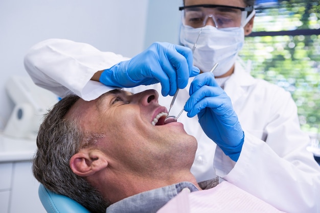 Hombre feliz recibiendo tratamiento dental por dentista