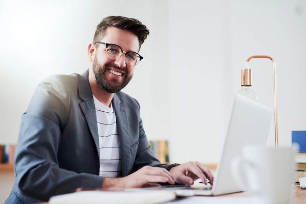 Hombre feliz retrato y portátil en casa para el trabajo remoto planificación y horario para la productividad Escritor creativo gafas y computadora en el escritorio para la oportunidad nueva idea y revisión de libros en Internet