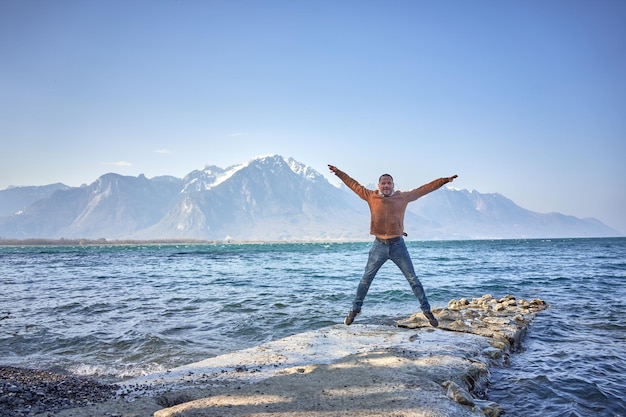 hombre feliz salta en el aire en el lago suiza