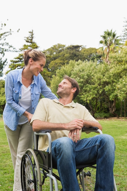 Hombre feliz en silla de ruedas hablando con pareja