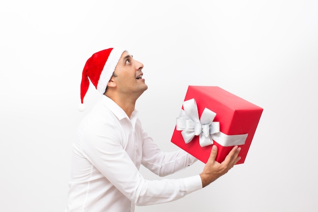 Hombre feliz con sombrero de Santa y regalo de cogida