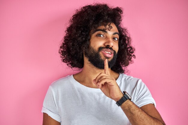 Hombre feliz sonriendo alegremente aislado en estudio con fondo rosa, chico positivo árabe posando