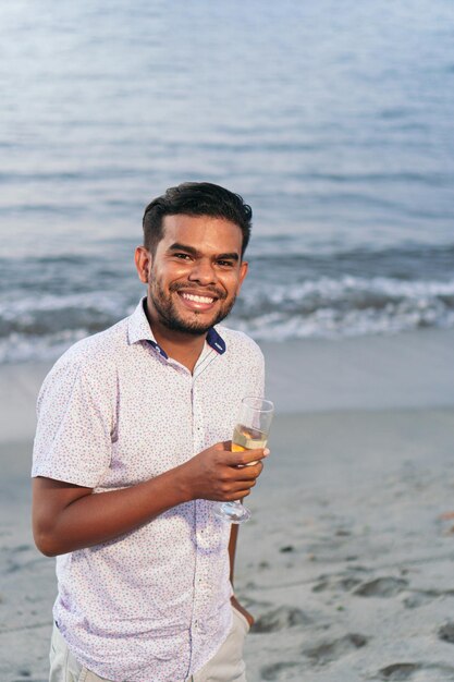 Hombre feliz sosteniendo una copa de vino en una celebración. Concepto de celebración de fin de año