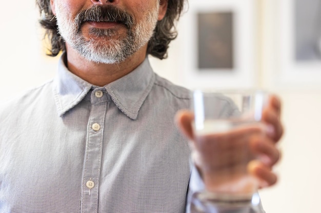 Hombre feliz sosteniendo un vaso de agua dentro