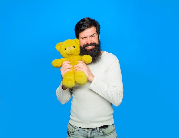 Hombre feliz sostiene osito de peluche celebración navideña de peluche hombre sonriente abraza osito de peluche o cumpleaños