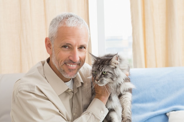 Hombre feliz con su gato en el sofá