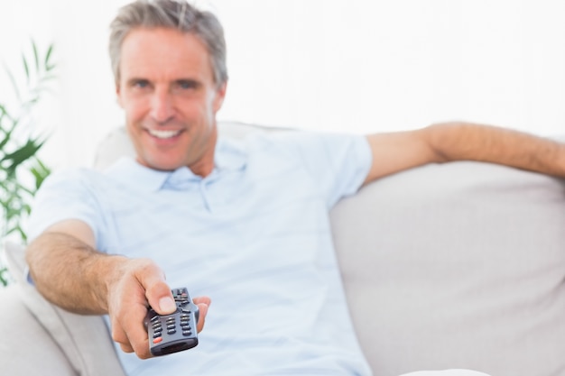 Hombre feliz en su sofá viendo la televisión