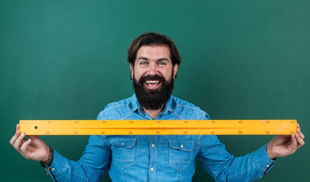 Hombre feliz con el tamaño medido en la regla herramienta matemática que mide la longitud