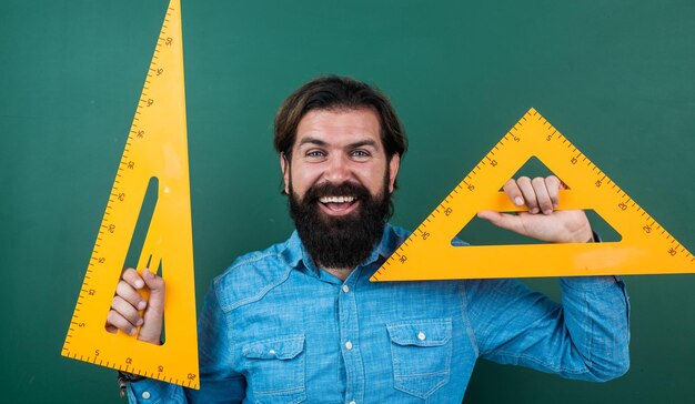 Hombre feliz con el tamaño medido en la regla de triángulo herramienta de matemáticas escuela de matemáticas