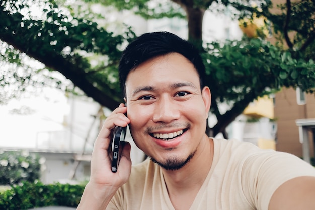 El hombre feliz tiene una conversación en el teléfono inteligente.