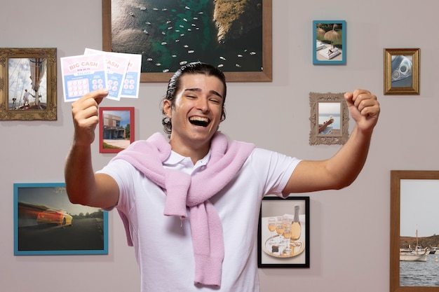 Hombre feliz de tiro medio con boletos de lotería