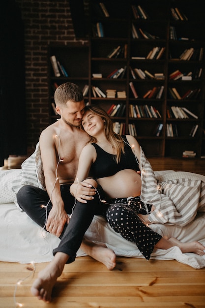 Hombre feliz tocando el vientre de la mujer embarazada sonriente