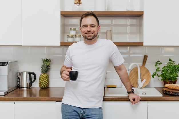 Hombre feliz tomando café en la cocina