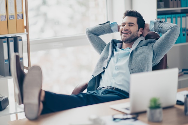 Hombre feliz en traje trabajando en el escritorio