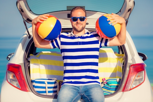 Hombre feliz viajar en coche Persona divirtiéndose en la playa Concepto de vacaciones de verano