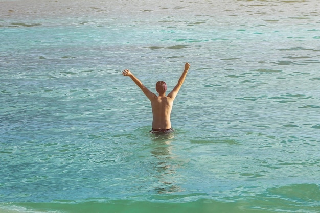 Hombre feliz en la vista trasera del mar