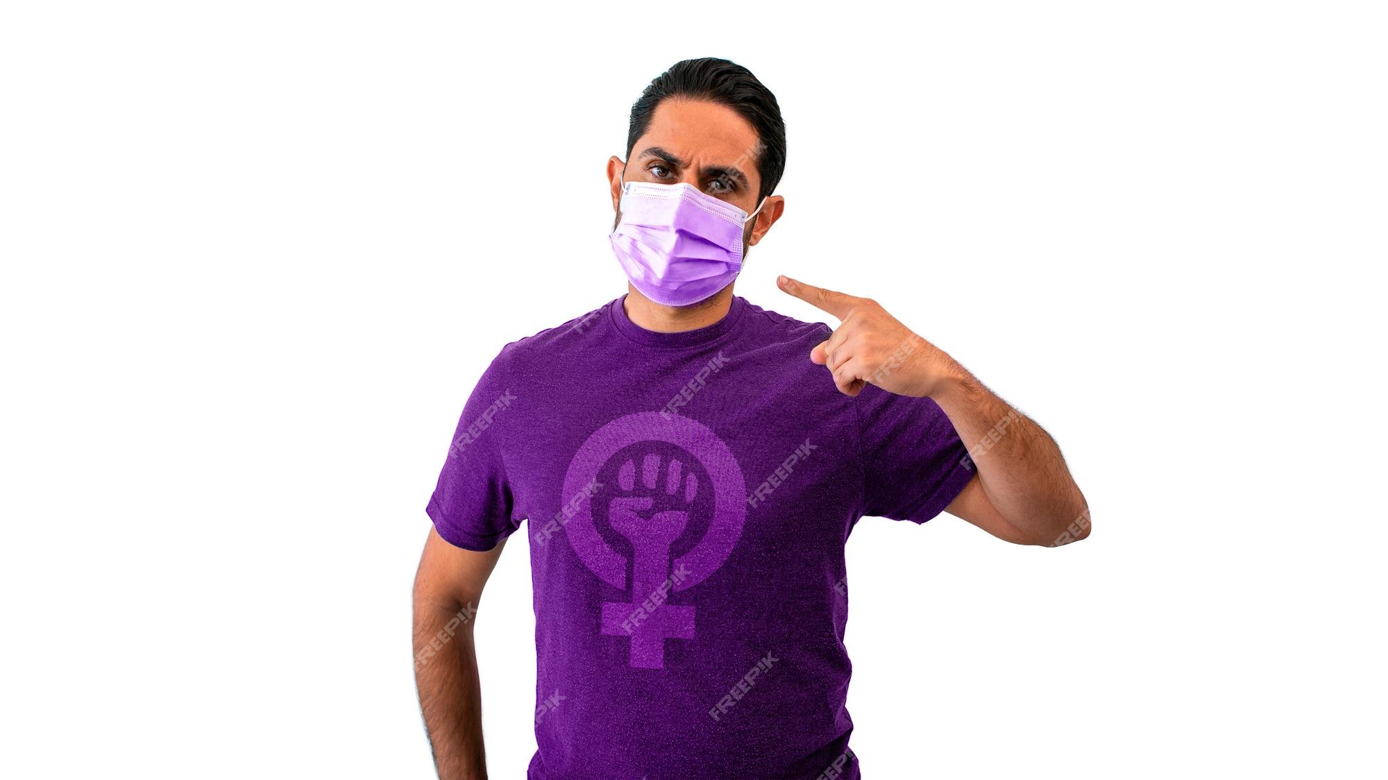 Hombre feminista con camisa morada con signo de género femenino y apuntando a una máscara facial estéril el coronavirus, aislado en un de fondo blanco. concepto de pandemia de