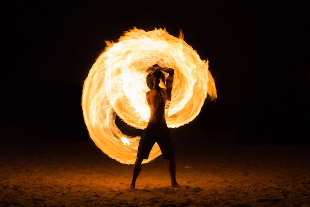 Foto hombre fire show en la playa