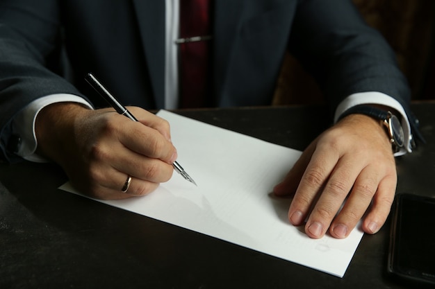 Hombre firmando un documento con una pluma estilográfica