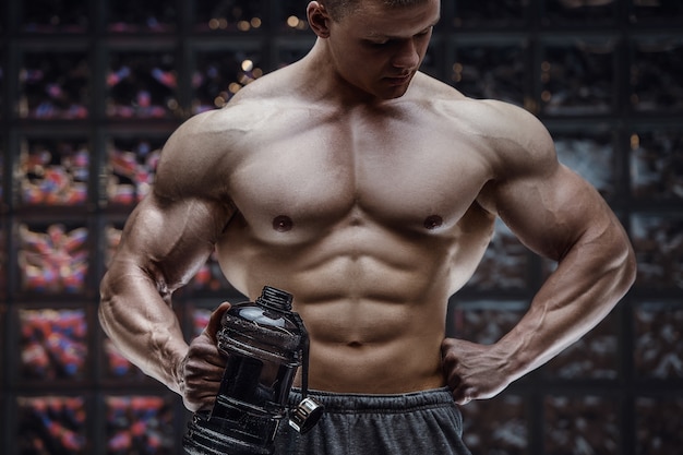 Hombre de fitness en el gimnasio de agua potable después del entrenamiento