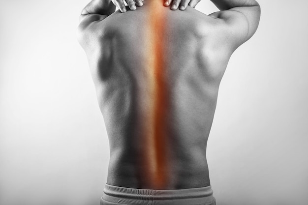 Foto hombre de fitness que muestra dolor en la médula espinal