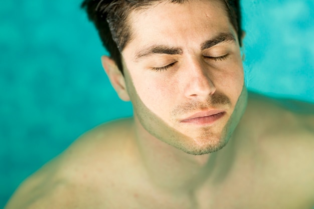 Hombre flotando en la piscina