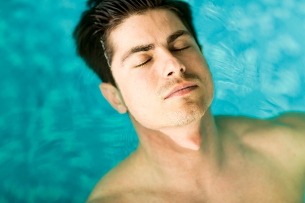 Hombre flotando en la piscina