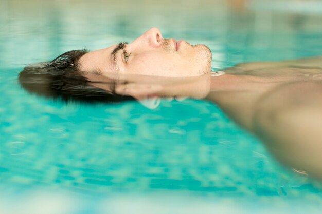 Foto hombre flotando en la piscina