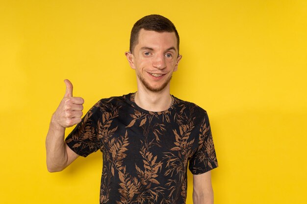 El hombre en el fondo amarillo dando un pulgar hacia arriba