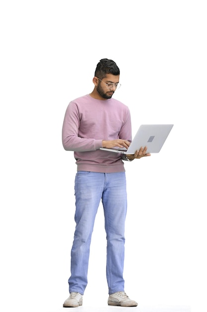 Un hombre en un fondo blanco a toda altura usa una computadora portátil