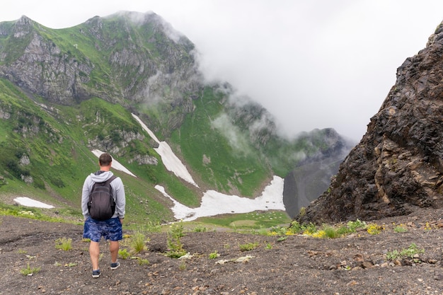 Hombre en el fondo de las montañas Persona viaja en las montañas Camping para escolares Turismo de montaña Un viaje apasionante Aficiones