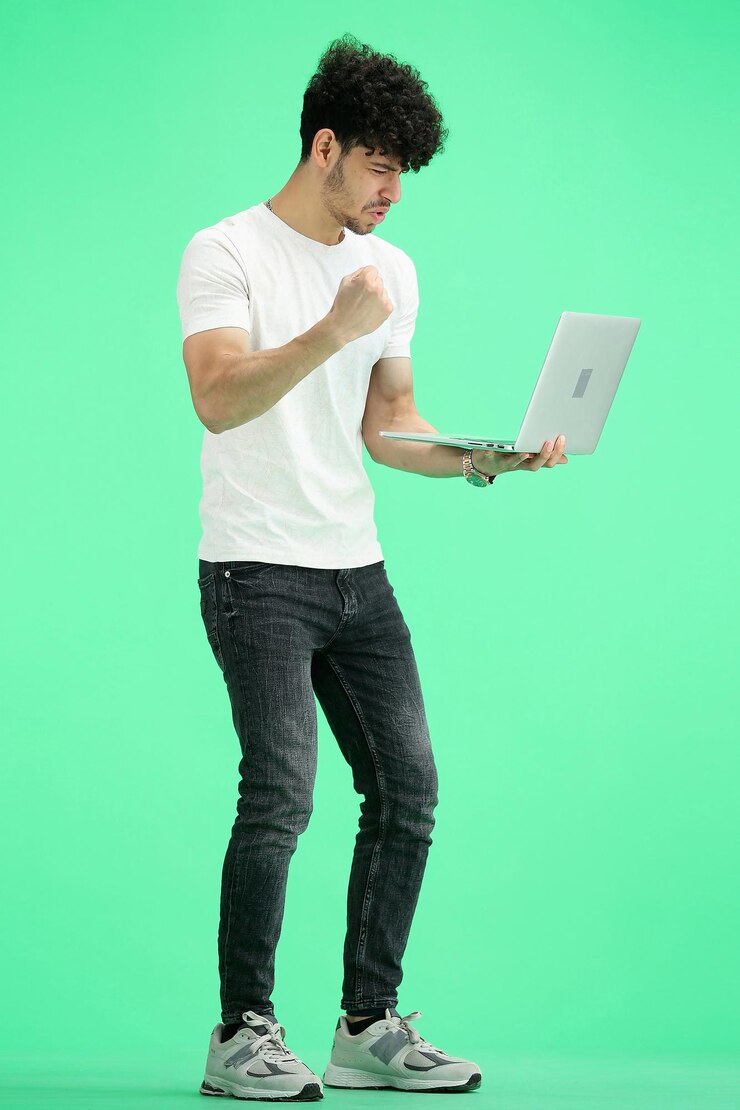Foto un hombre en un fondo verde a toda altura con una computadora portátil