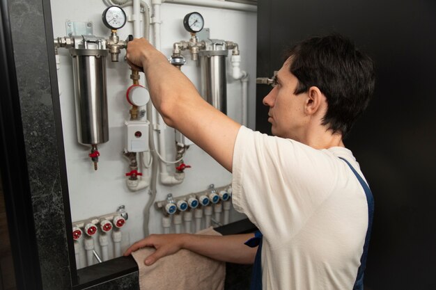 Foto hombre fontanero trabajando para arreglar problemas en la casa del cliente