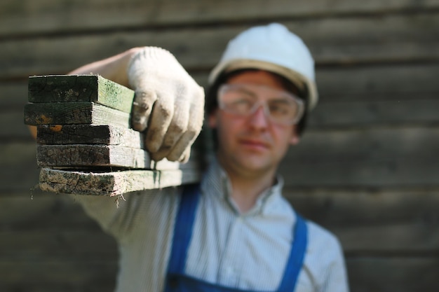 Un hombre en forma de constructor repara una casa.