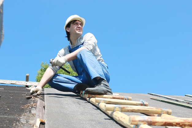 Un hombre en forma de constructor repara una casa.