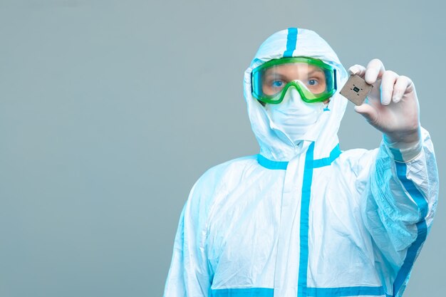 Foto el hombre en forma estéril tiene un microprocesador en sus manos, primer plano